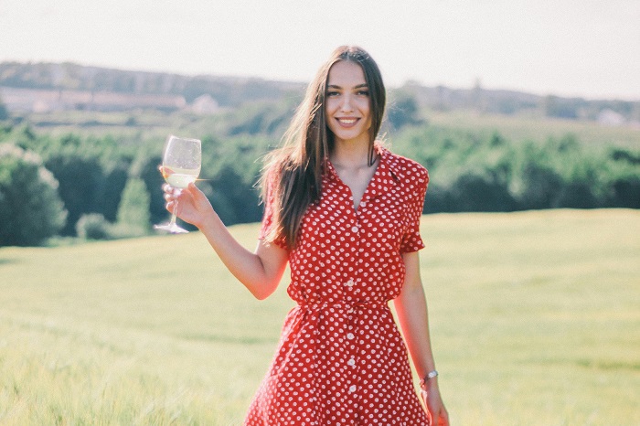 Ragazza con calice di vino bianco