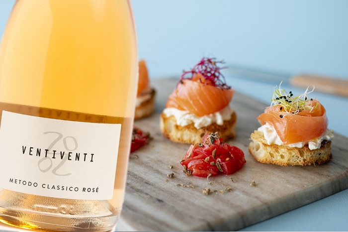 Crostini di salmone norvegese, stracciatella, concassé di San Marzano e polvere di capperi di Pantelleria e Lambrusco di Modena Rosato Metodo Classico di Cantina Ventiventi